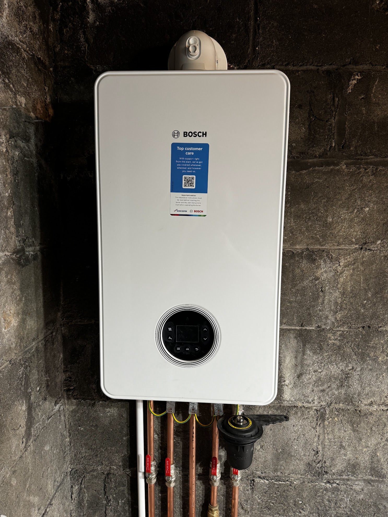 Worcester Bosch gas boiler newly fitted to a block wall with isolation valves and system filter