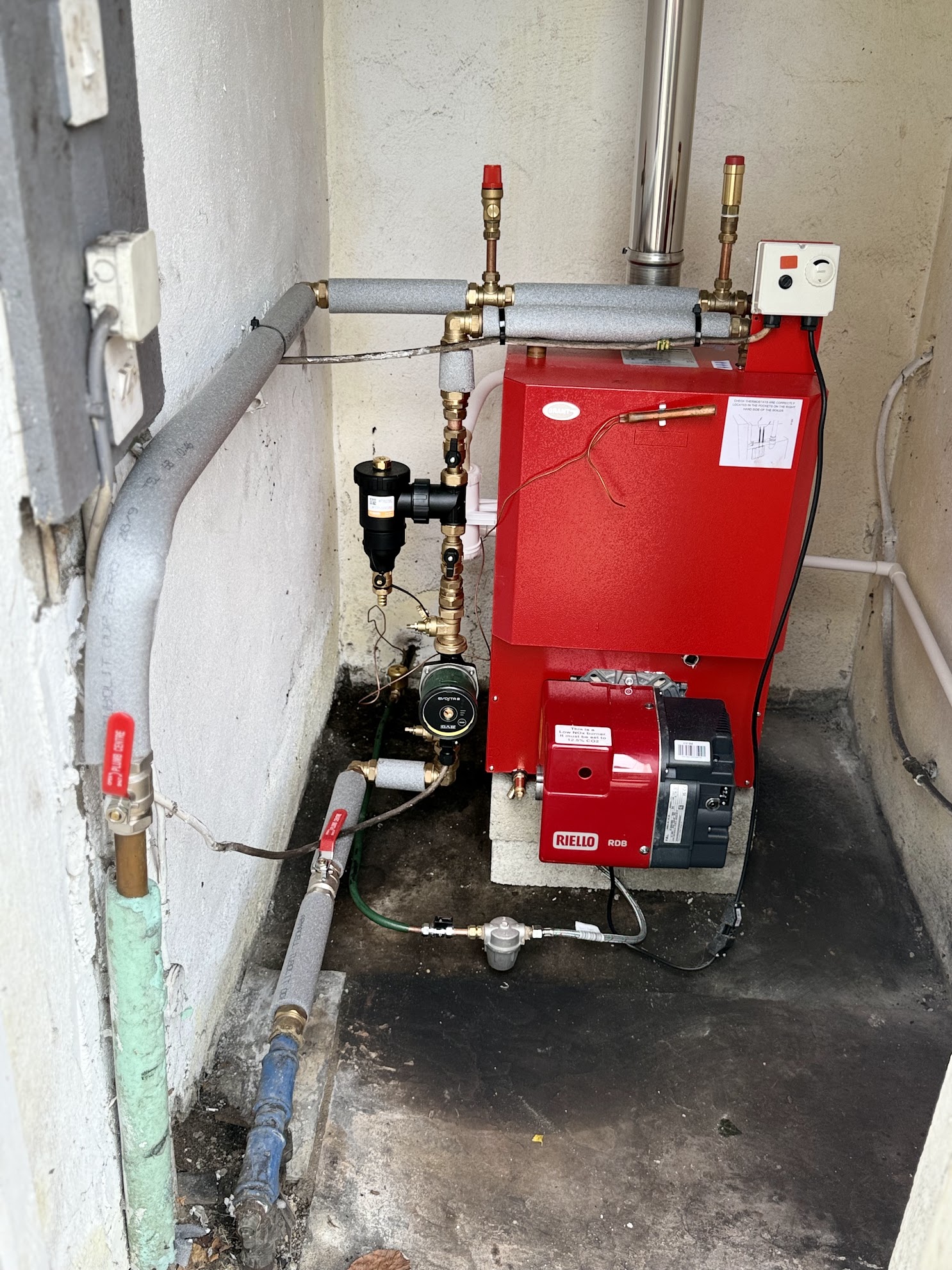 External oil boiler with Riello burner, pump and insulated pipework serviced by Freeman Plumbing Services